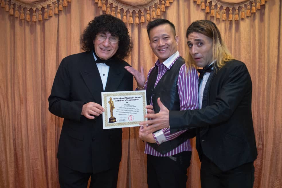 magicSam pictured receiving a certificate alongside two other people.