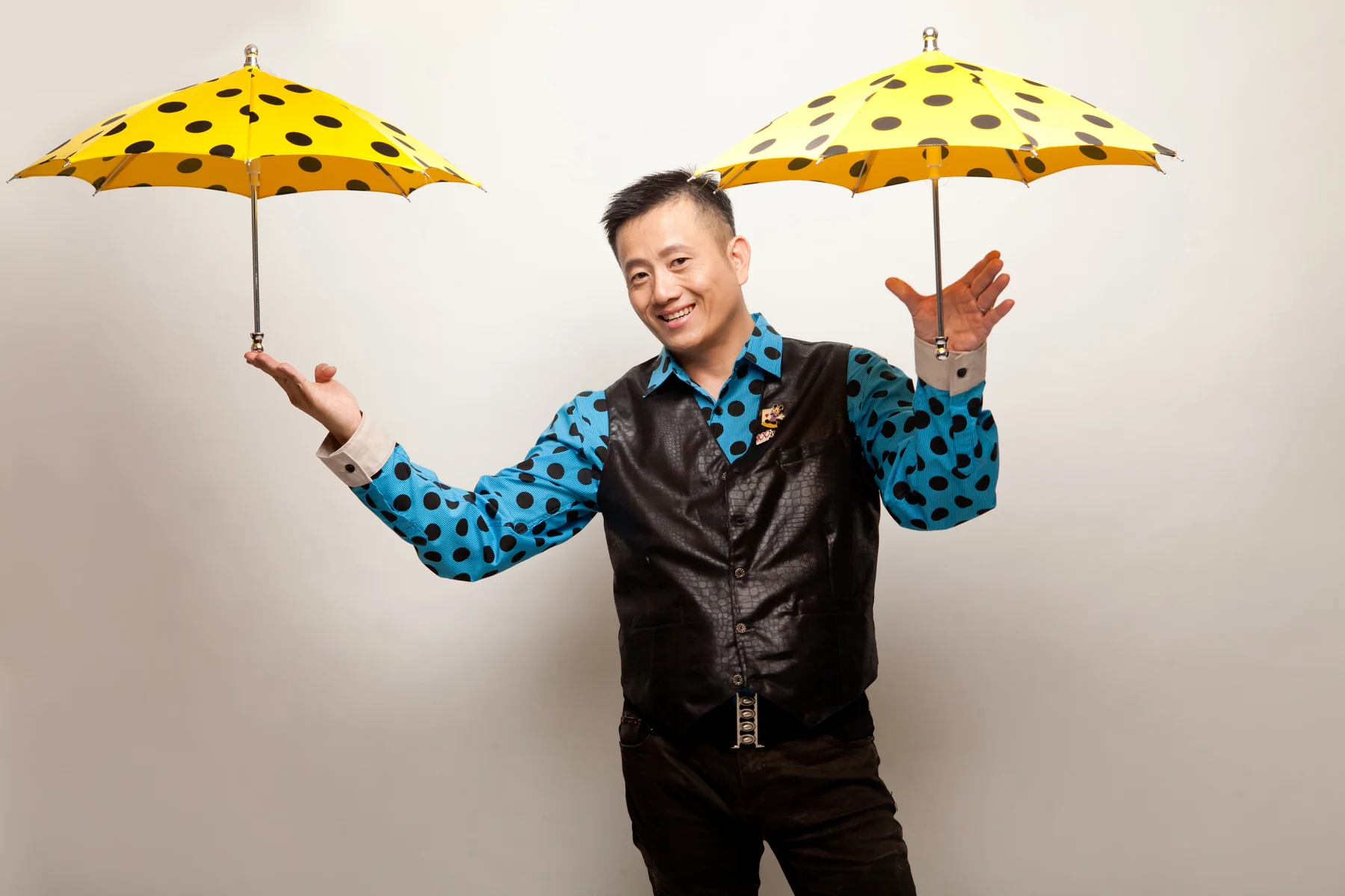 magicSam balancing two bright yellow umbrellas.